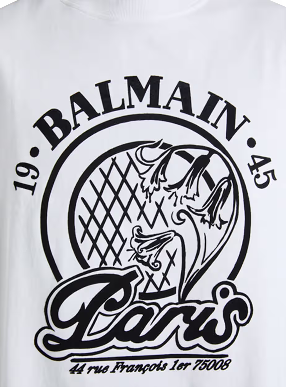 Balmain Paris Sleeveless Graphic T-Shirt Elevate your casual wardrobe with this premium white sleeveless T-shirt from Balmain Paris. Designed with a bold black logo print and signature Paris-inspired artwork, it combines luxury fashion with modern streetwear aesthetics. The clean white base and relaxed sleeveless cut make it ideal for warm weather and effortless styling. - Image 2