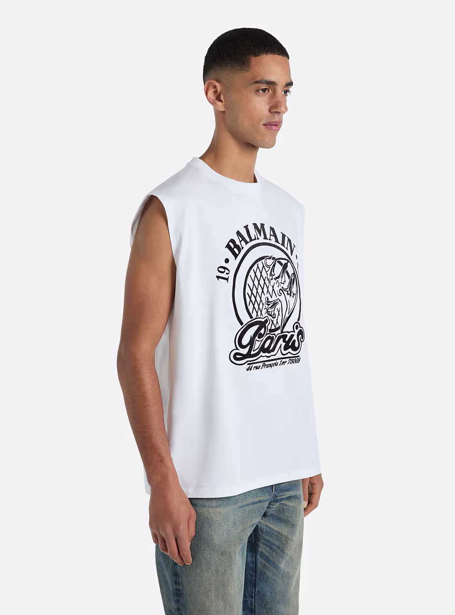 Balmain Paris Sleeveless Graphic T-Shirt Elevate your casual wardrobe with this premium white sleeveless T-shirt from Balmain Paris. Designed with a bold black logo print and signature Paris-inspired artwork, it combines luxury fashion with modern streetwear aesthetics. The clean white base and relaxed sleeveless cut make it ideal for warm weather and effortless styling. - Image 3